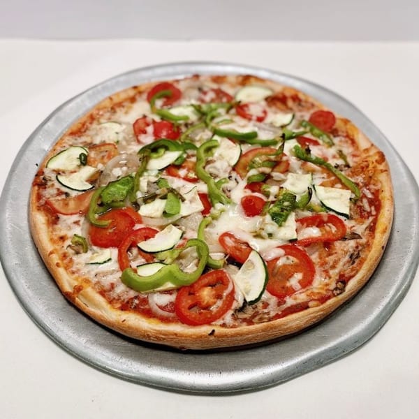 ZIPS' NY Pizza with tomatoes, zucchini, green peppers, and onions on a metal tray.