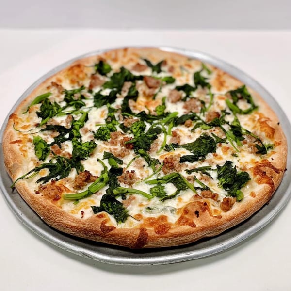 ZIPS' NY Pizza with white sauce, mozzarella, sausage, and broccoli rabe on a metal tray.
