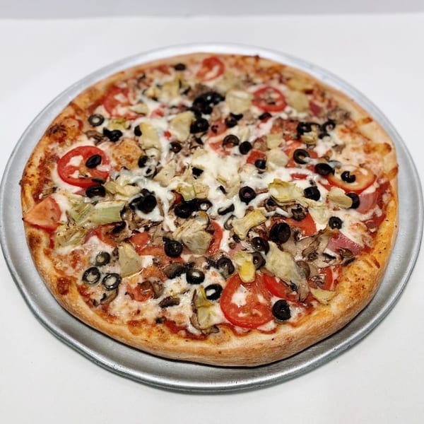ZIPS' NY Pizza with tomatoes, black olives, artichoke hearts, and mushrooms on a metal pan.